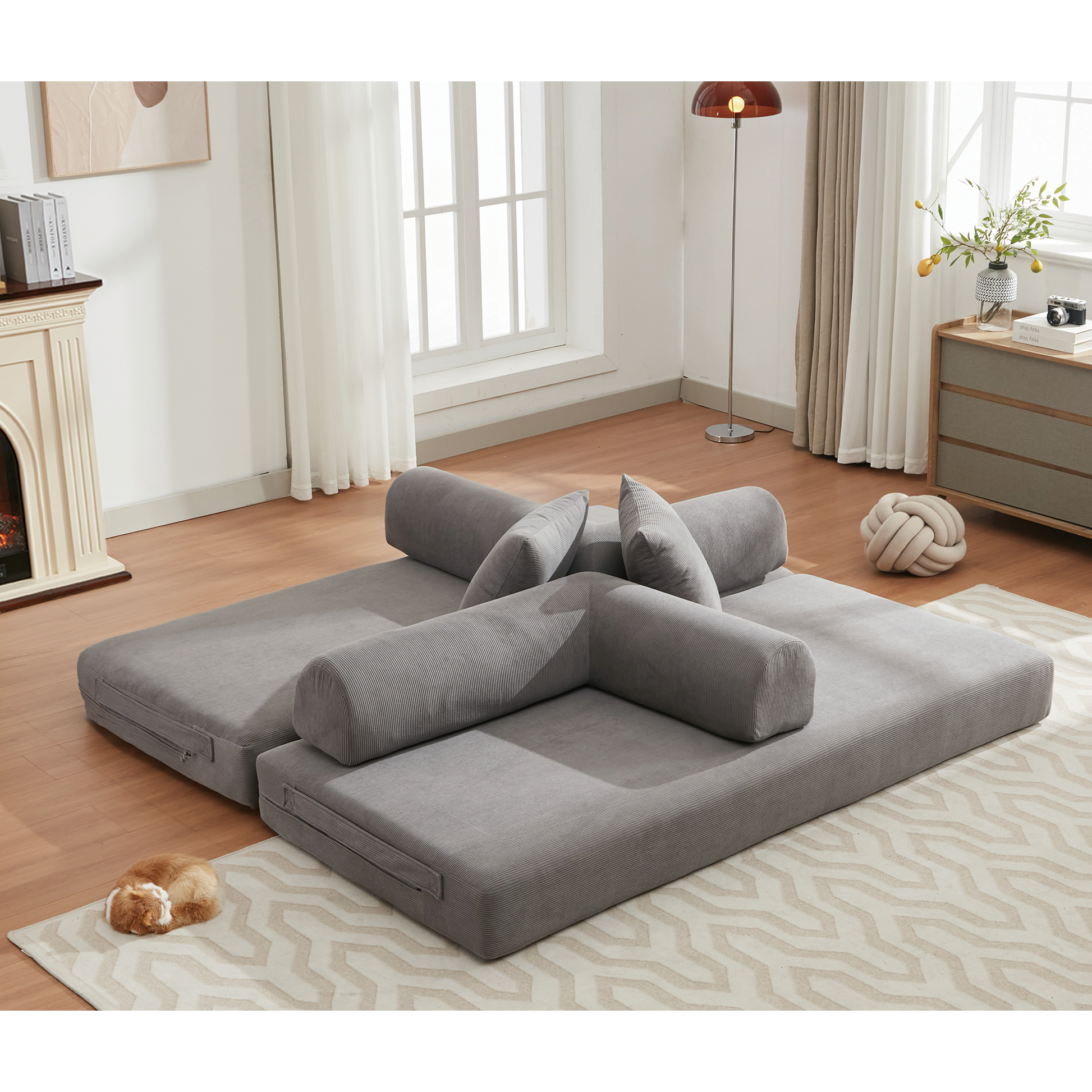 Gray modular floor couch with corduroy fabric and bolster pillows for versatile seating