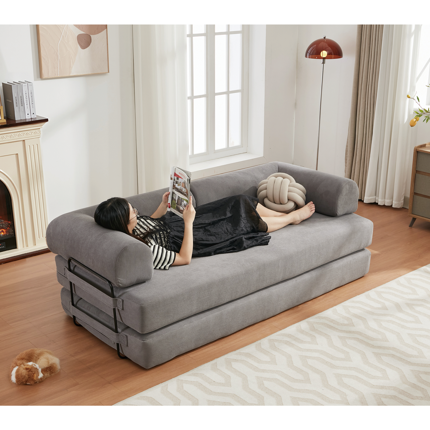 Grey upholstered sofa bed with a woman reading modern living room furniture
