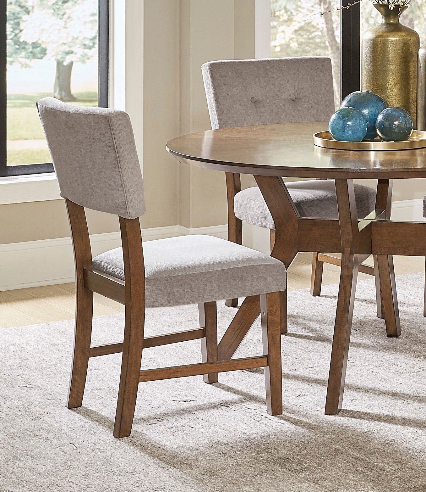 Upholstered dining chair with a gray fabric seat and back and a rich wood frame perfect for any modern dining set
