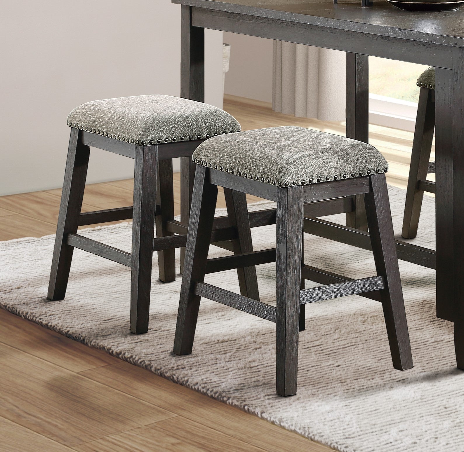 Dark wood counter stools with grey upholstered seats and nailhead trim