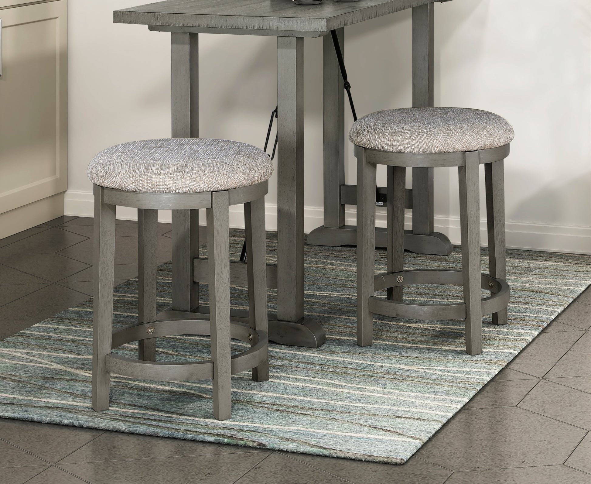 Gray wooden bar stool with textured gray fabric seat perfect for a kitchen island