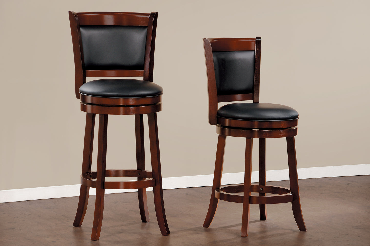 Two wooden swivel bar stools with black leather seats and backs