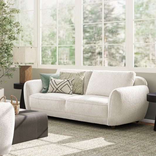 Plush cream boucl sofa with geometric throw pillows for modern living room decor