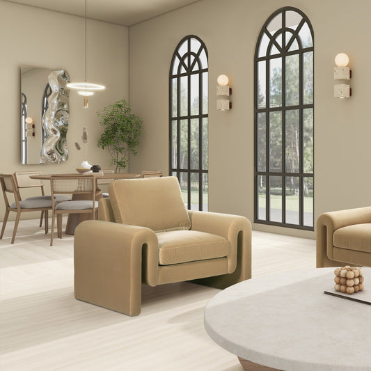 Plush beige velvet armchair with curved armrests perfect for a cozy living room