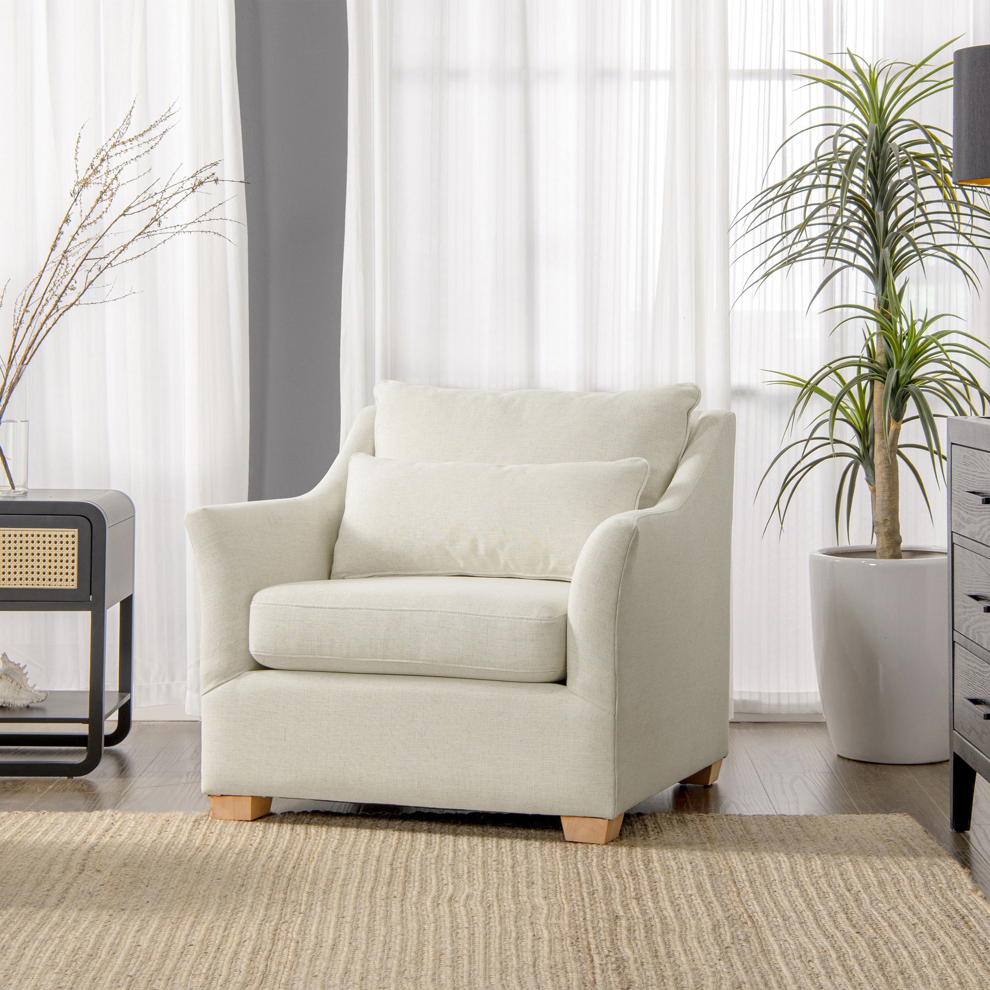 Comfortable cream upholstered armchair with plush seat and back cushions