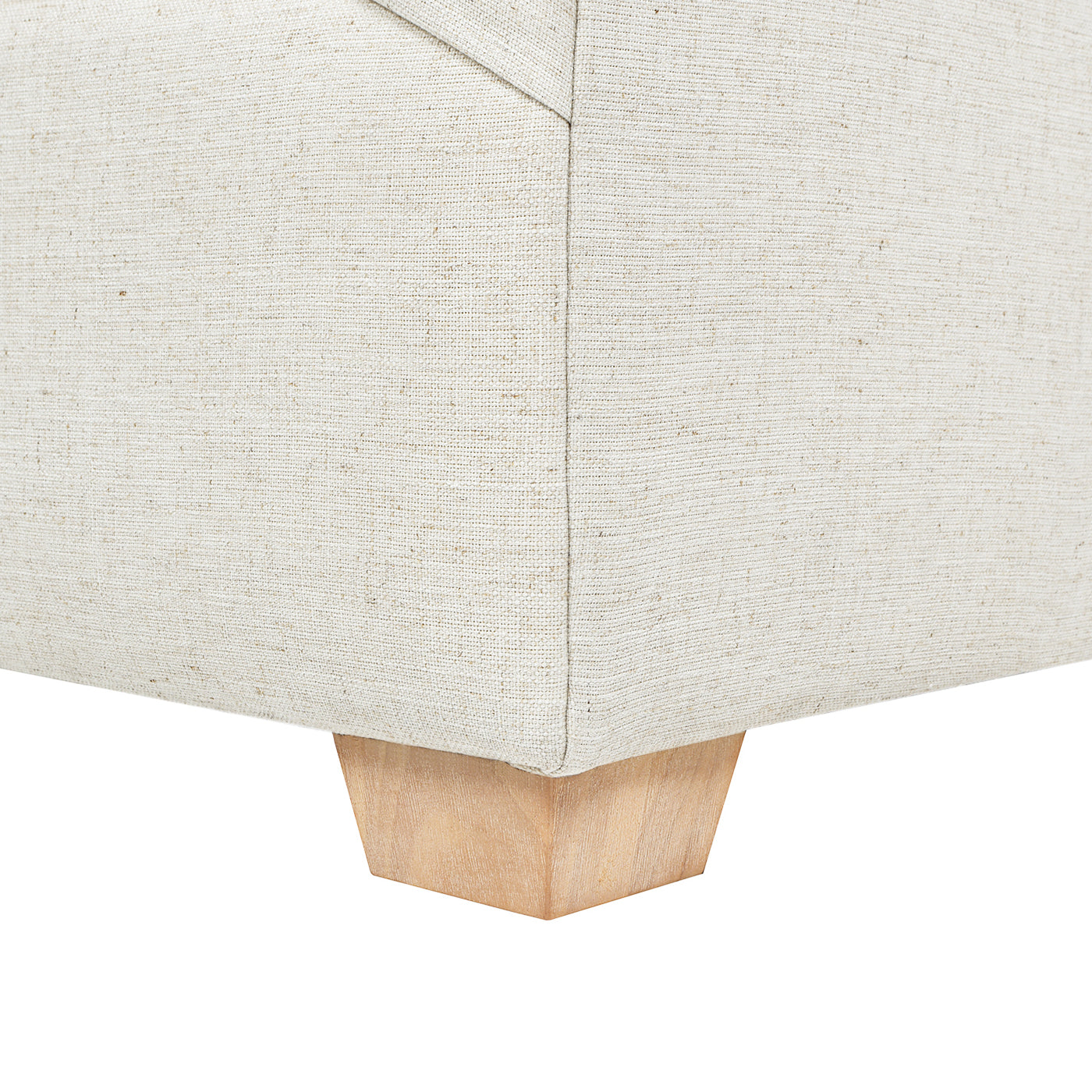 Natural linen upholstered sofa corner with tapered wood leg detail