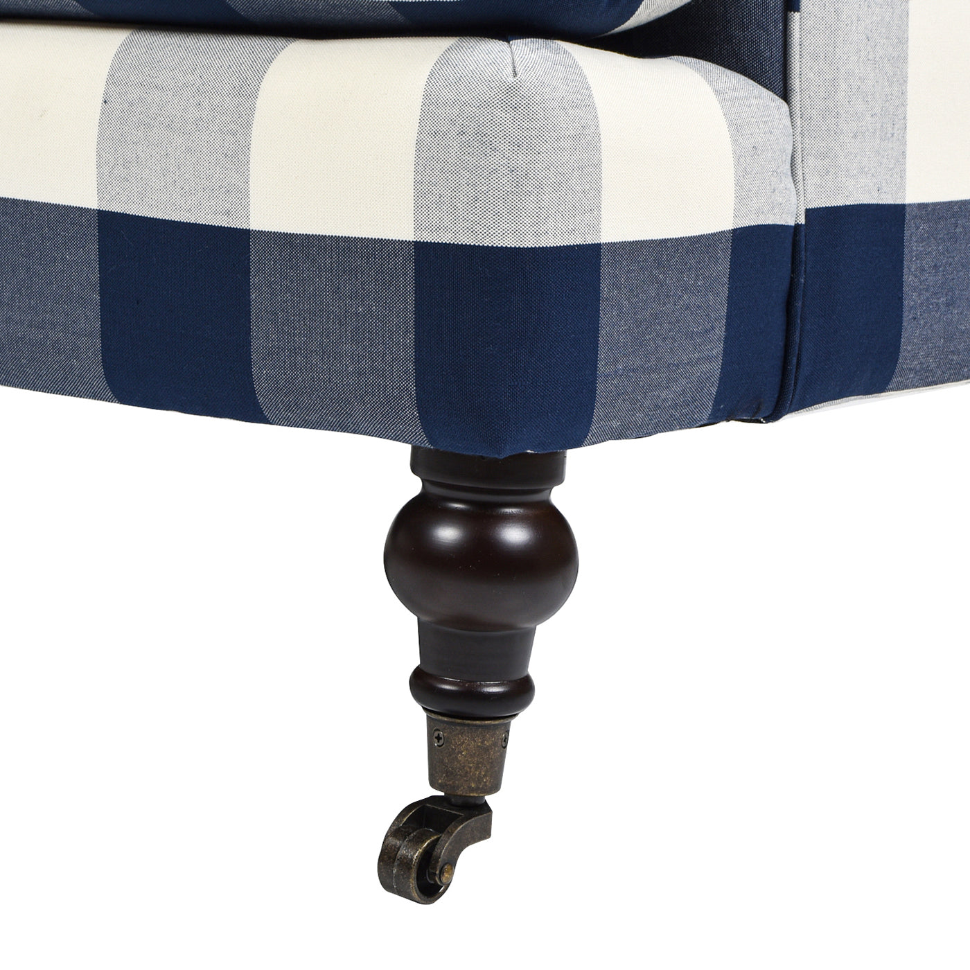 Closeup of navy and white buffalo check armchair leg with brass caster