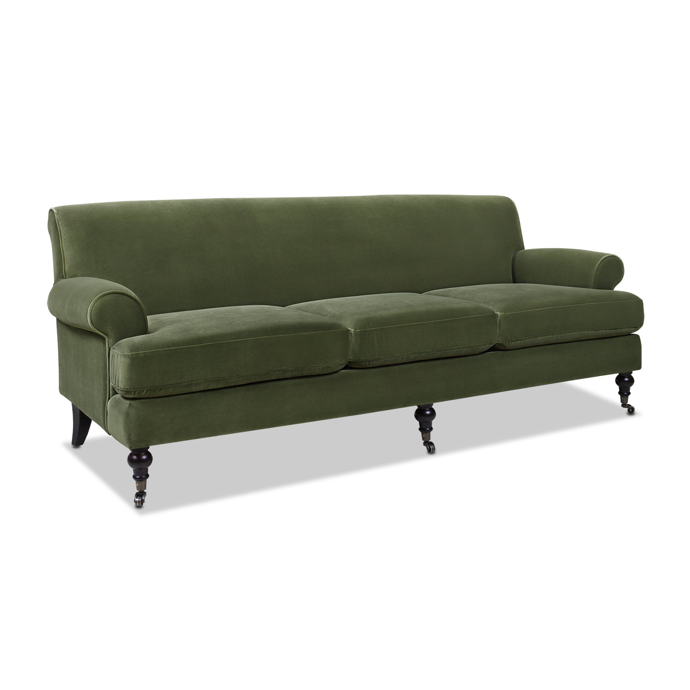 Emerald green velvet sofa with rolled arms and dark wooden legs on casters
