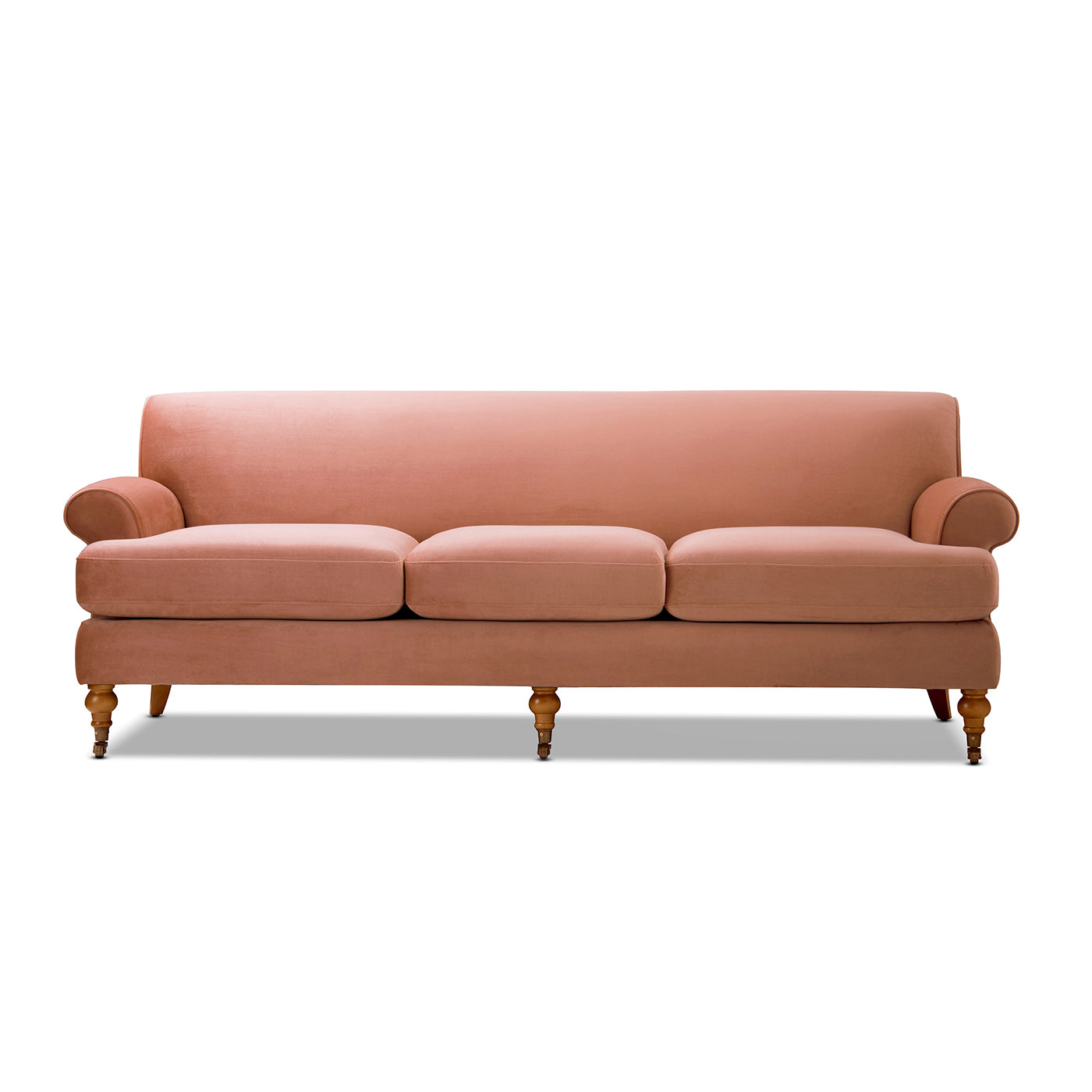 Blush pink velvet threeseater sofa with rolled arms and carved wooden legs
