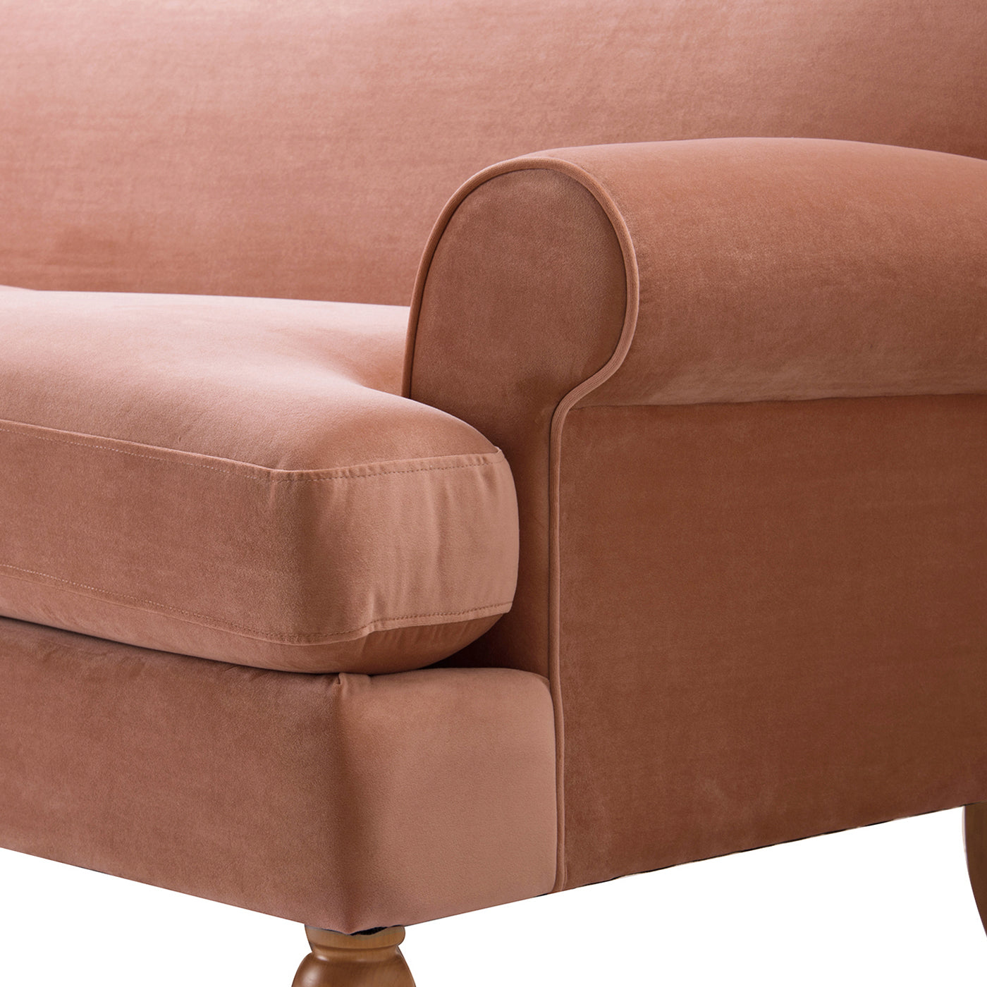 Closeup of plush rose gold velvet armchair armrest and cushion detail
