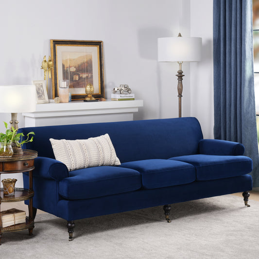 Deep blue velvet sofa with decorative cushion and ornate legs