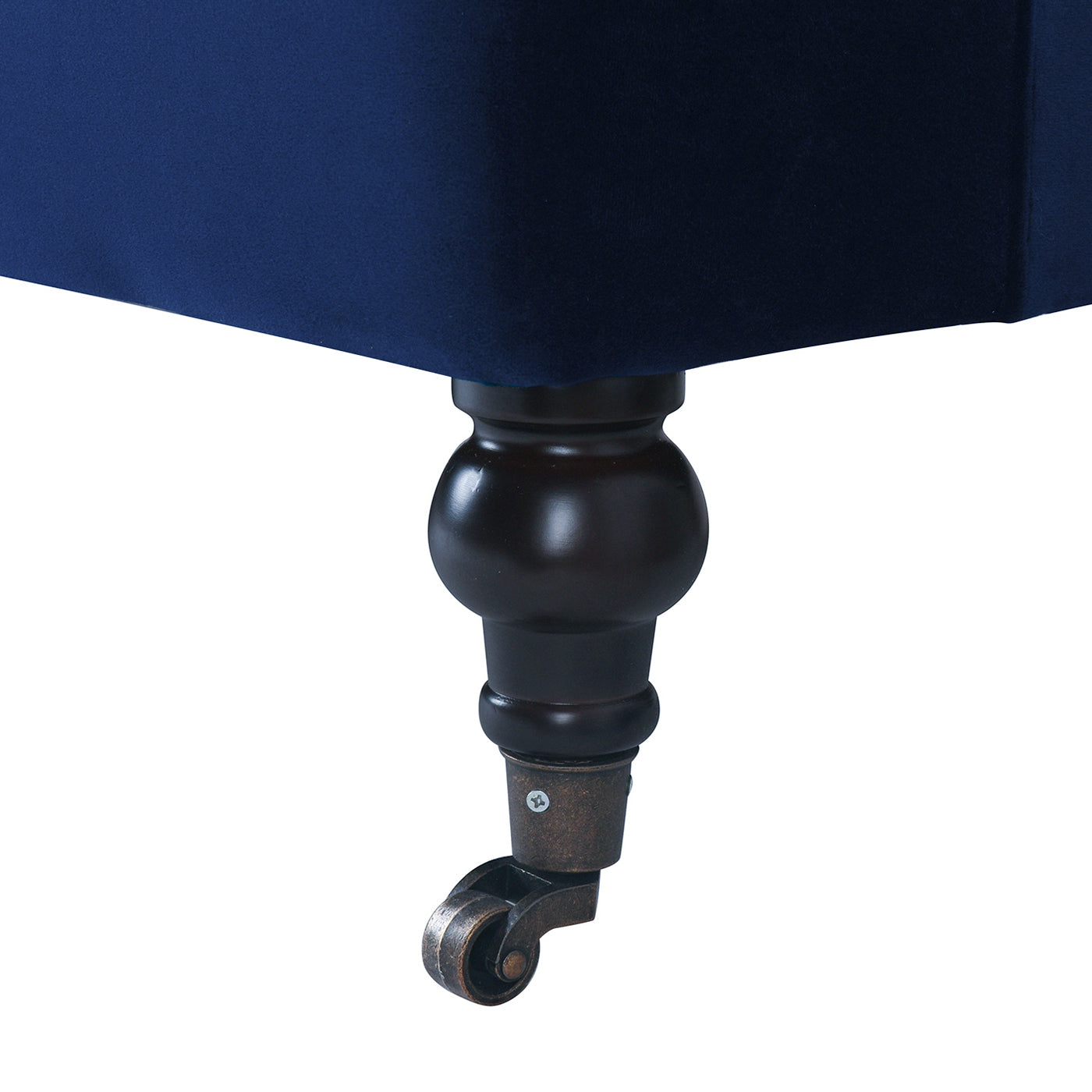 Dark wood furniture leg with brass caster wheel on navy velvet ottoman