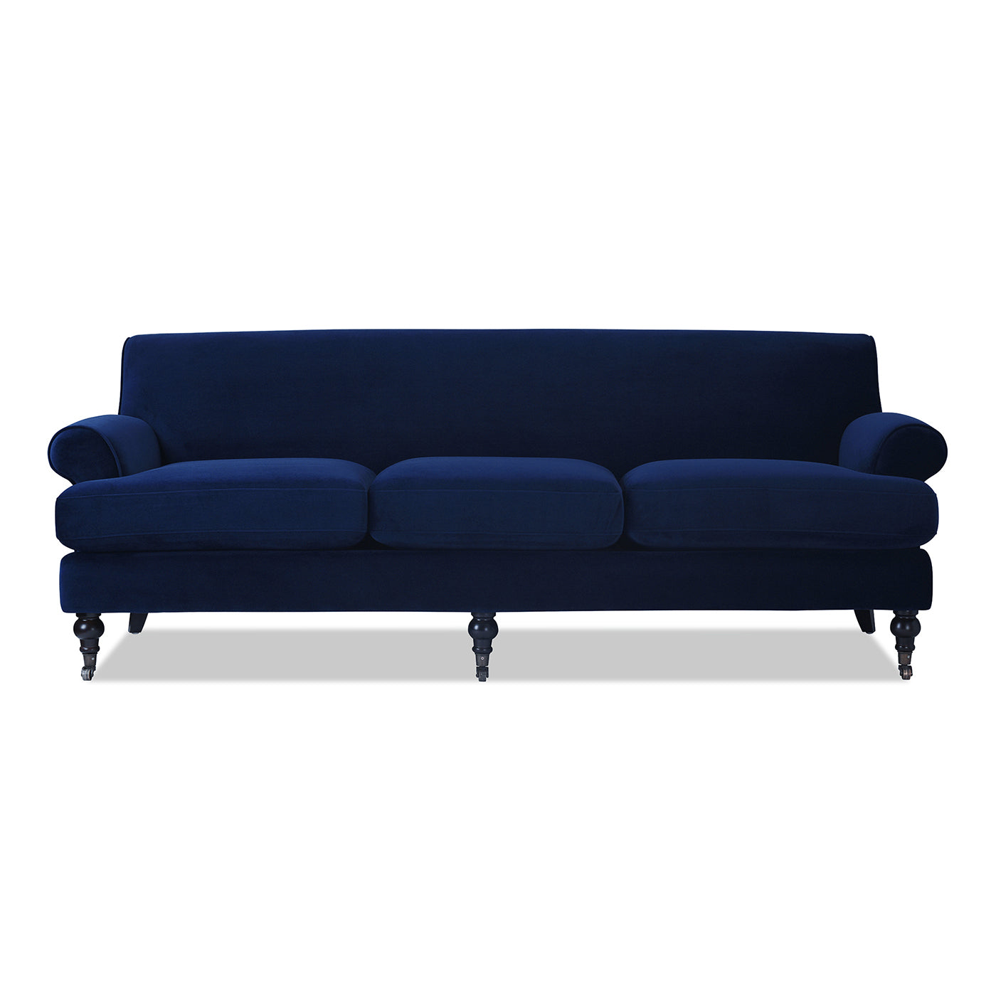 Navy velvet sofa with rolled arms and dark wooden legs on casters
