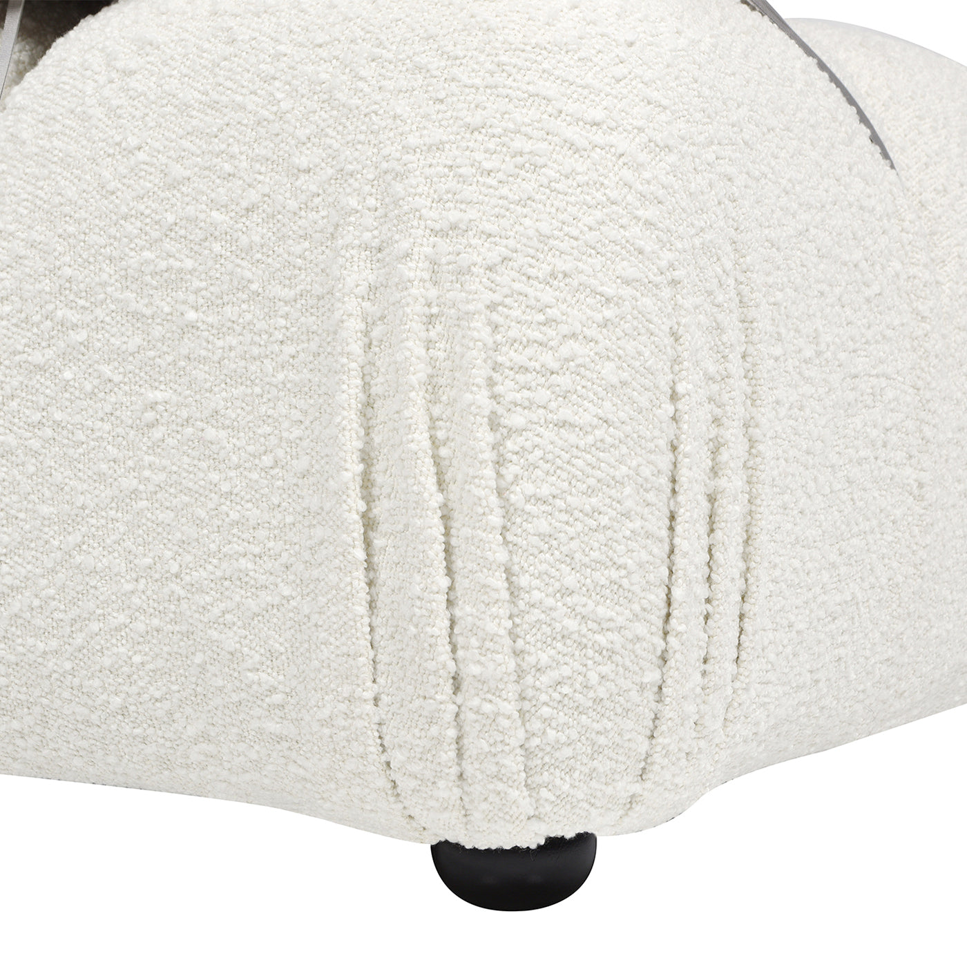 Closeup of textured cream fabric on a modern chair cushion showing intricate weave patterns and soft folds