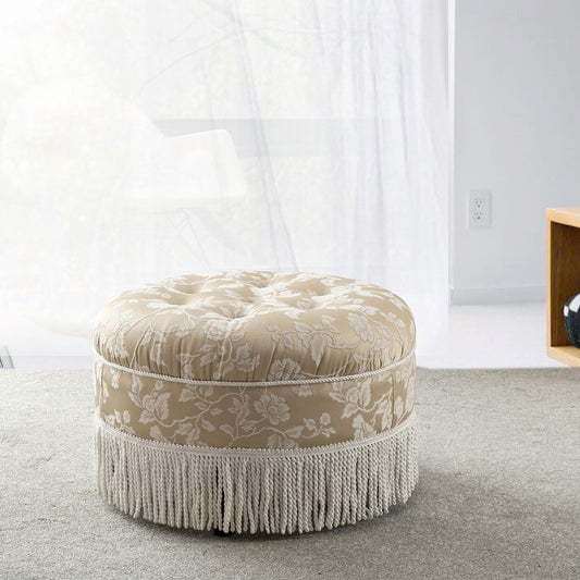 Tufted beige upholstered ottoman with floral pattern and fringe accent