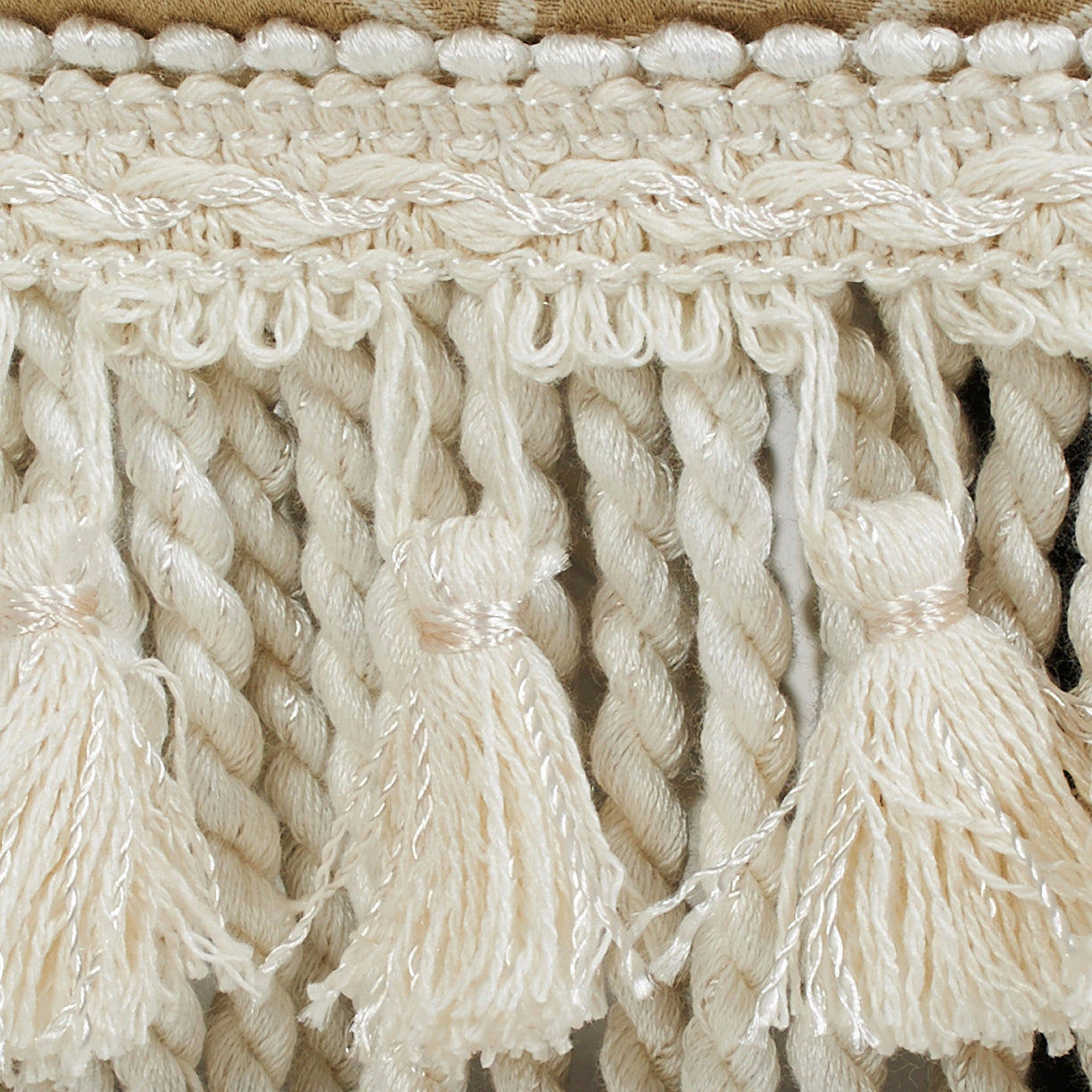 Closeup of cream tassel trim with thick braided cords and metallic silver threads