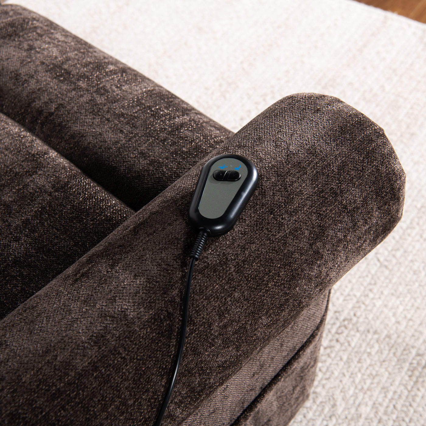 Closeup of a brown recliner armchairs armrest with a power lift control soft fabric texture