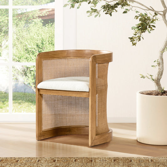 Natural wood armchair with woven cane back and a plush white seat cushion blending midcentury and coastal styles