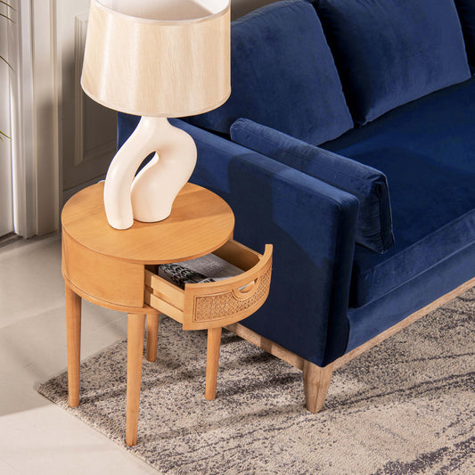 Abstract ceramic table lamp with a natural wood side table and blue velvet sofa