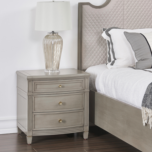 Gray distressed wood nightstand with three drawers and gold hardware