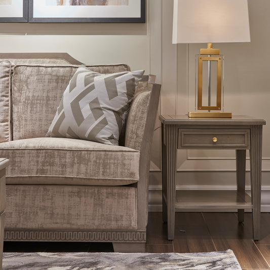 Textured beige upholstered sofa with chevron accent pillow on hardwood floor