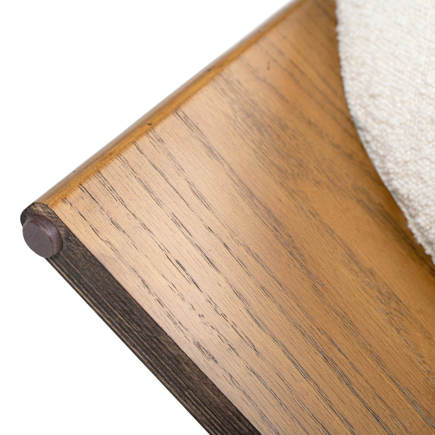 Closeup of a light brown textured wood furniture edge with a brown felt foot