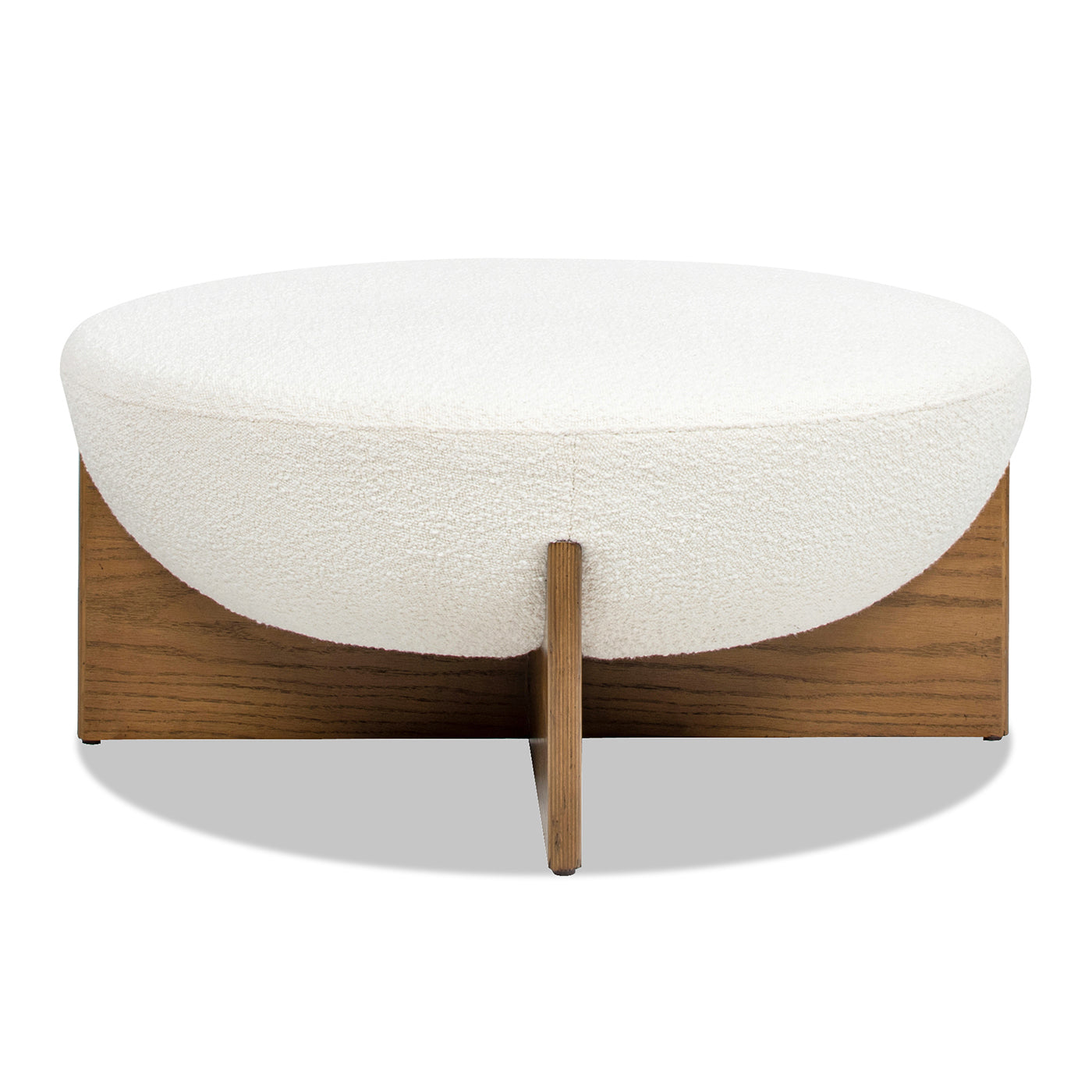 Cream boucl upholstered round ottoman with a natural wood base and angled legs