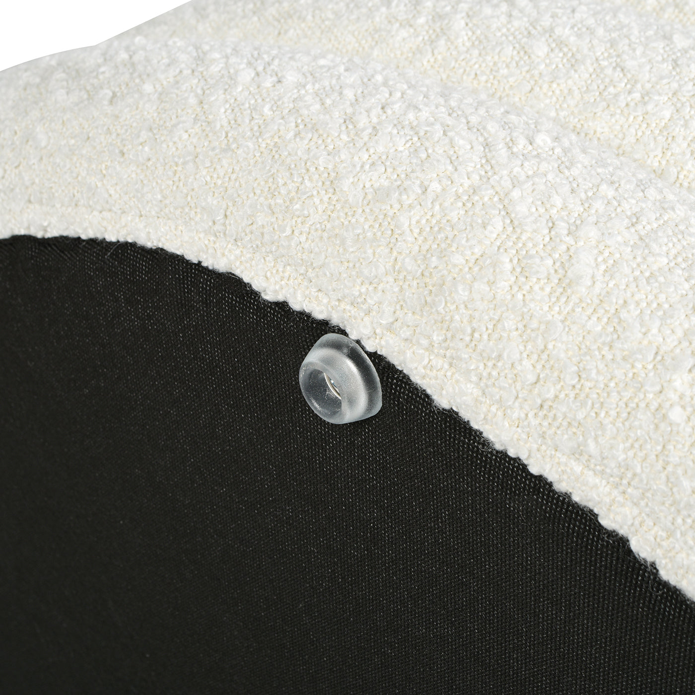 Closeup of textured cream boucle fabric on a furniture cushion with a clear protective foot