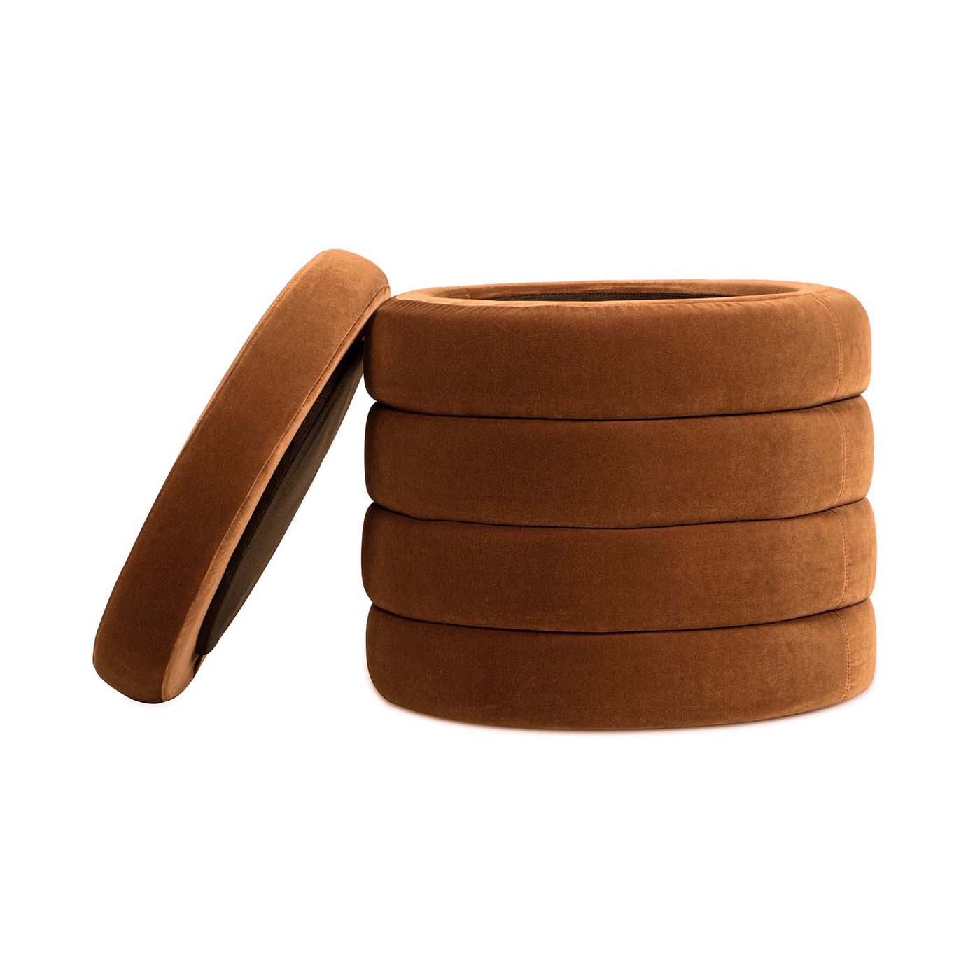 Stack of four brown velvet ringshaped cushions with one cushion leaning against it