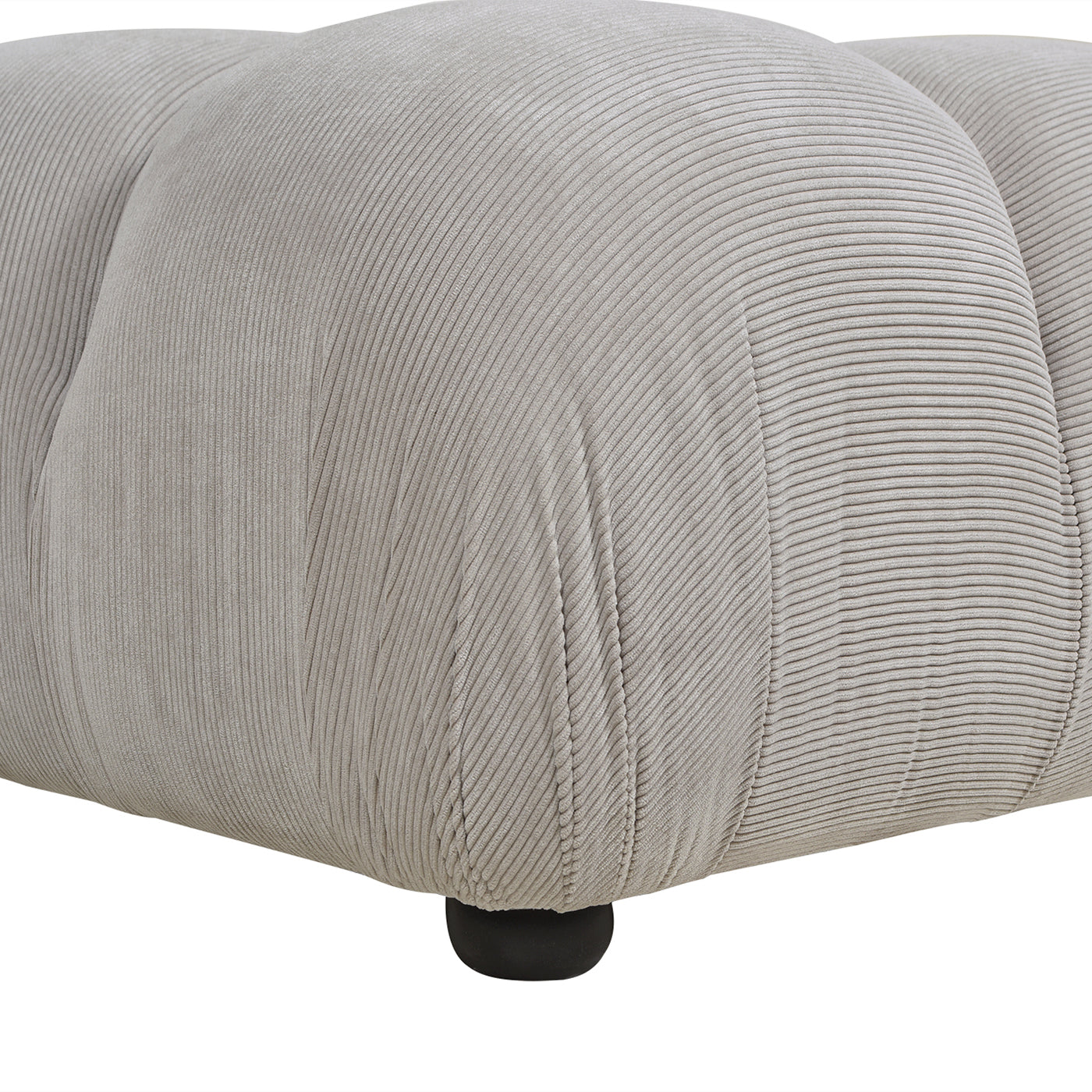 Closeup of a textured light grey corduroy ottoman with a single dark wood leg