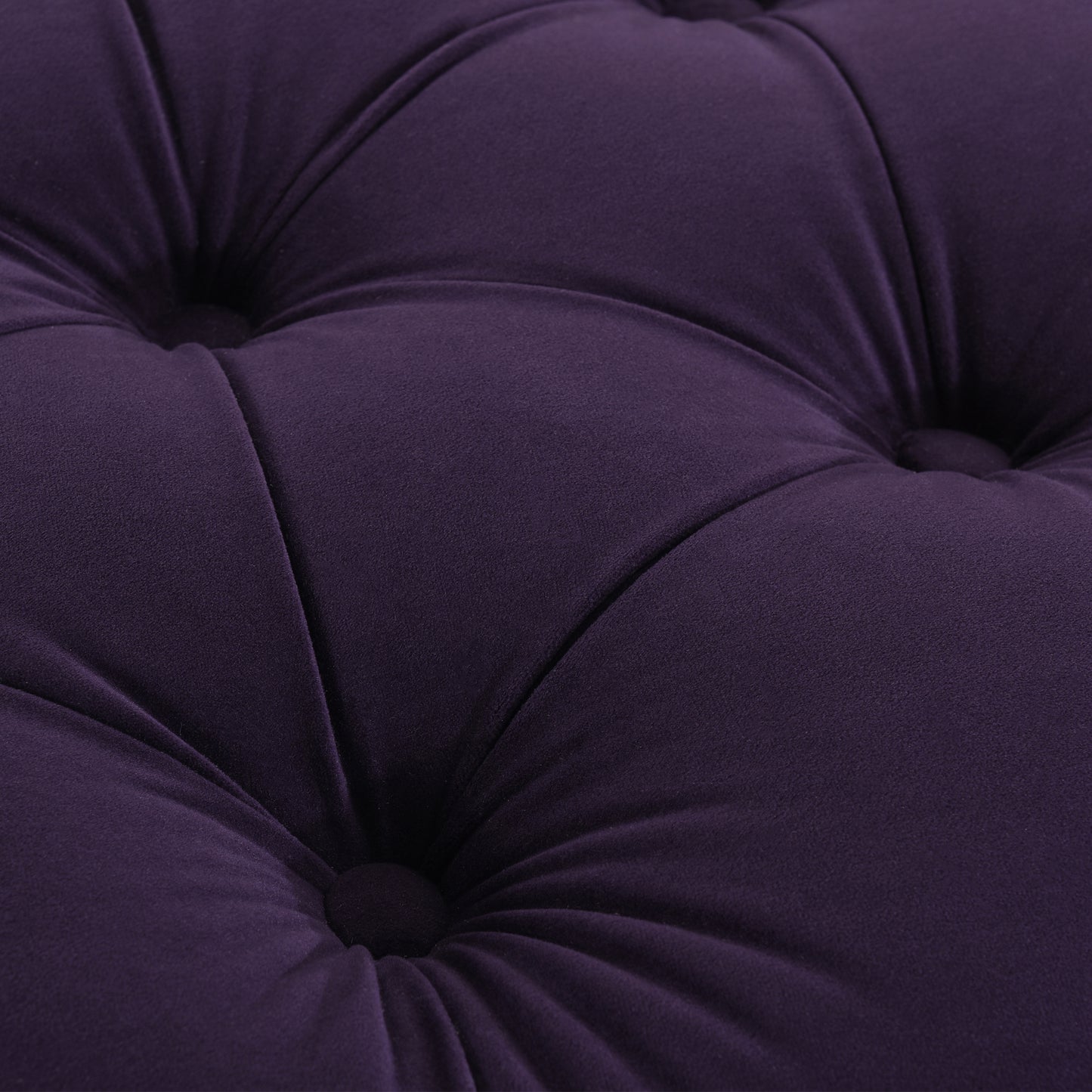 Closeup of plush purple velvet fabric with diamond tufting detail