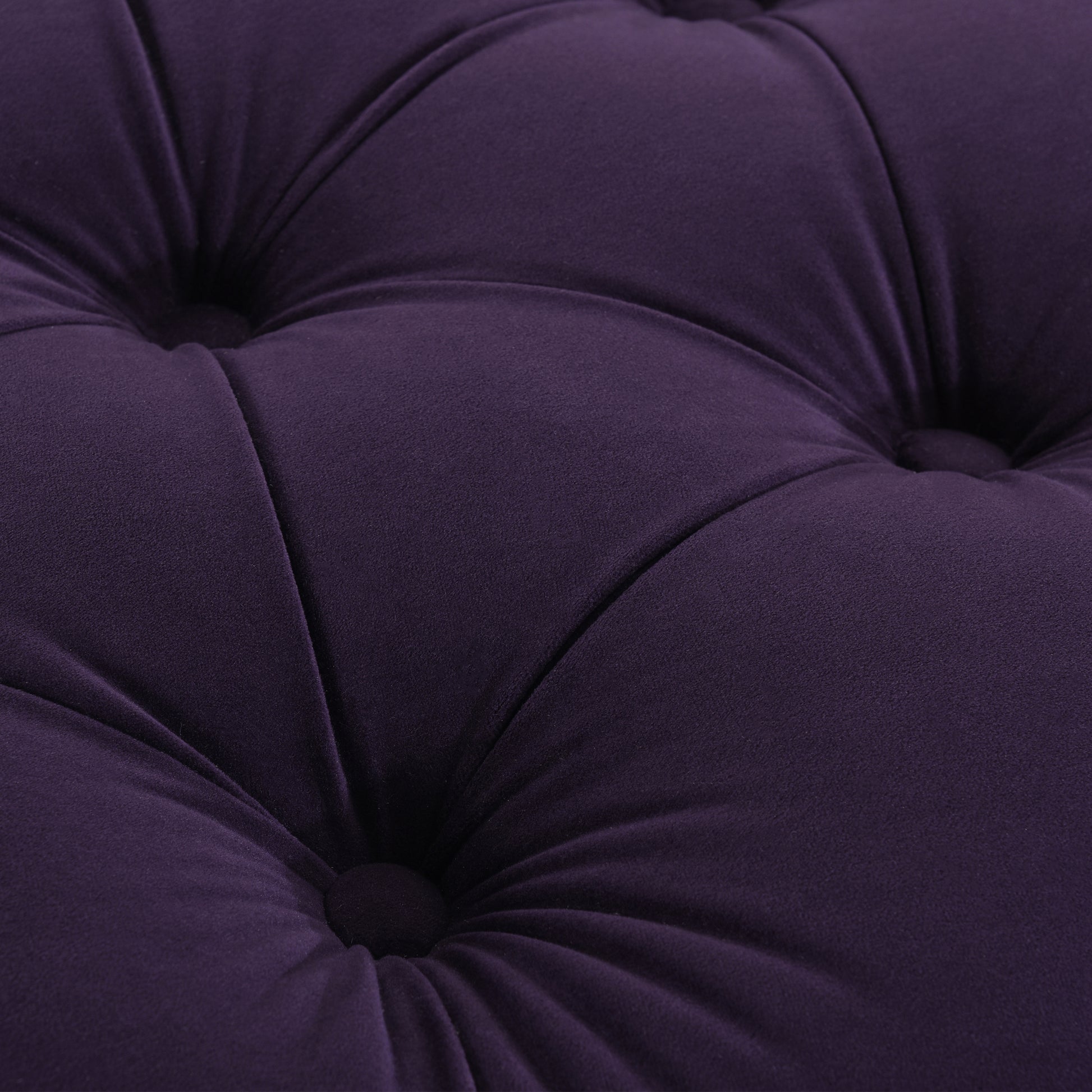 Closeup of plush purple velvet fabric with diamond tufting detail