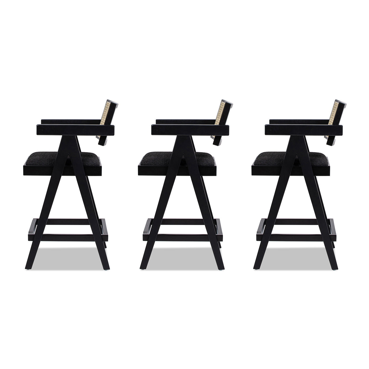Three black modern bar stools with cane backs and upholstered seats
