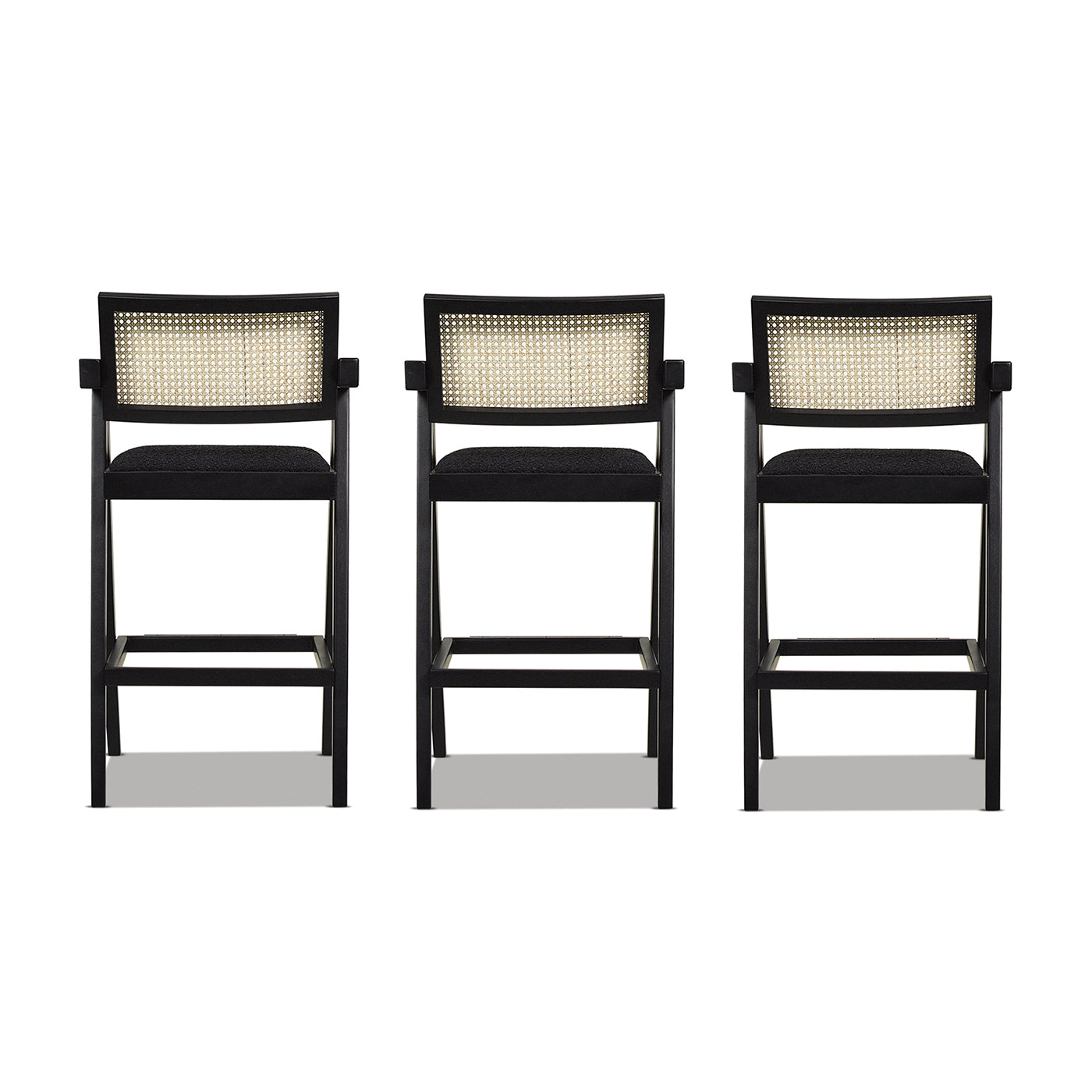 Three modern black counter stools with woven cane backrests and padded seats