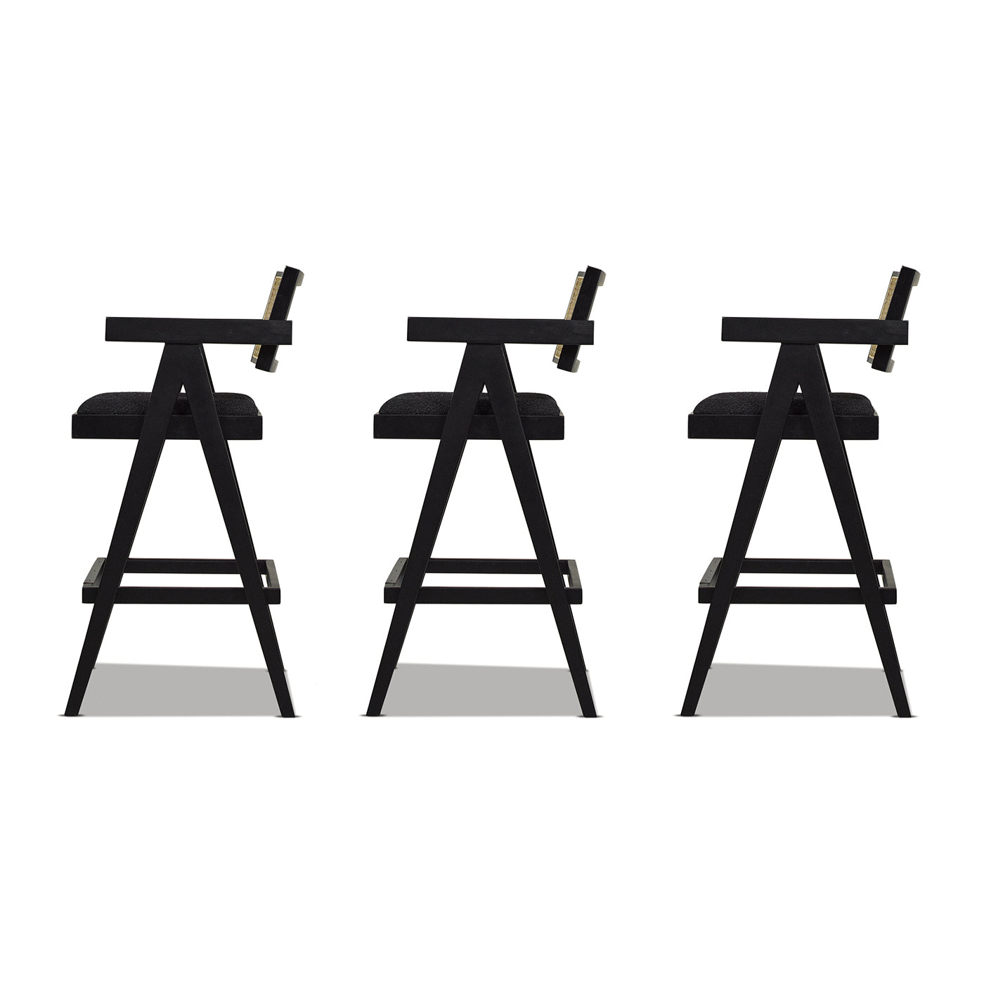 Three black modern counter stools with upholstered seats and metal accents