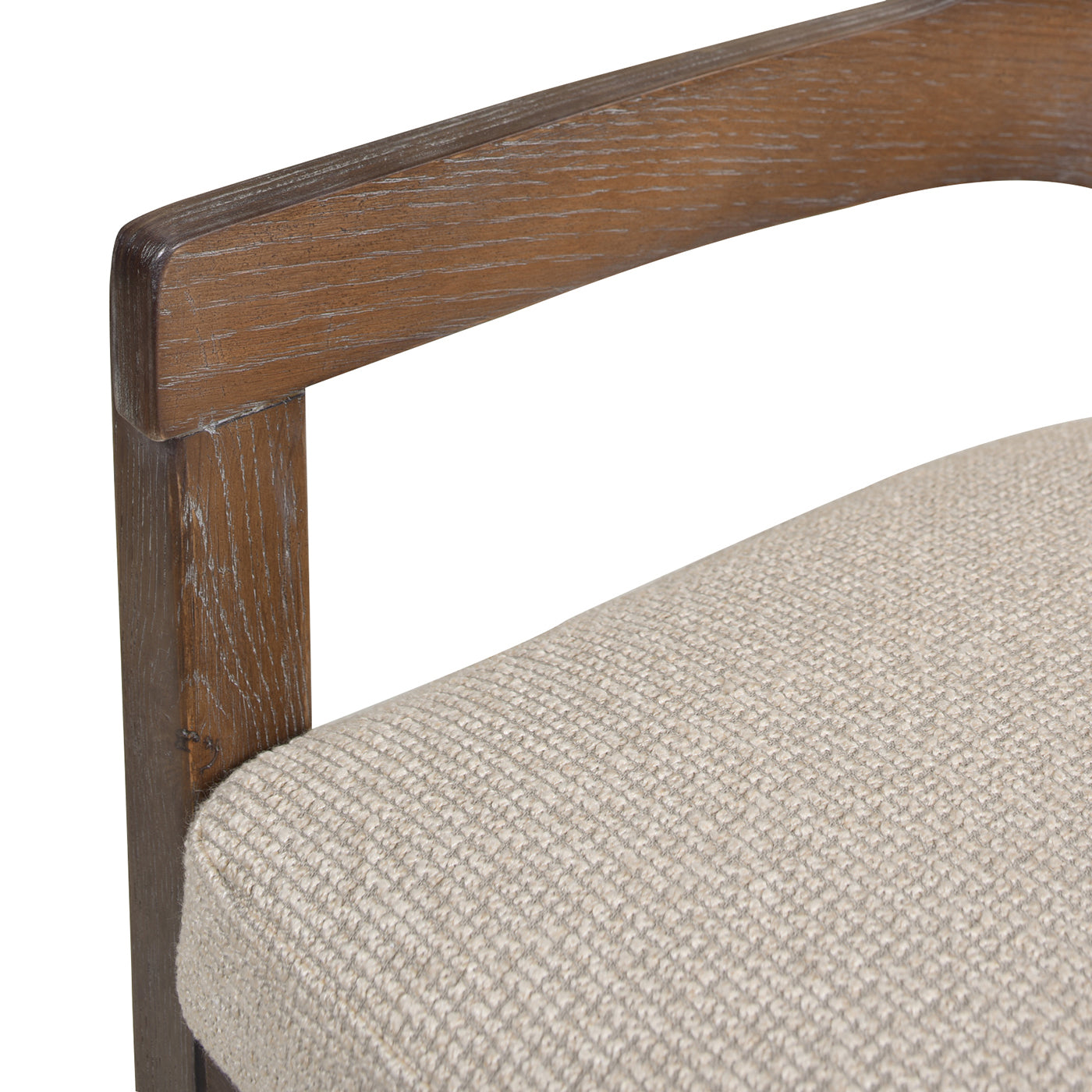 Close up of a textured beige upholstered chair seat and weathered oak wood armrest