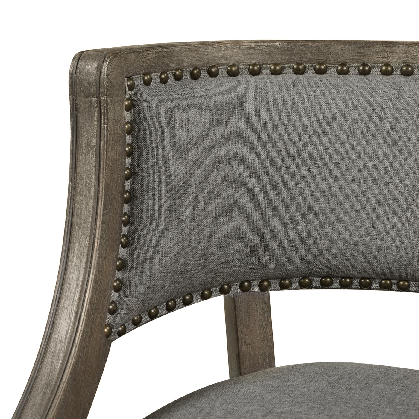 Close up of a grey linen upholstered armchair with antique brass nailhead trim