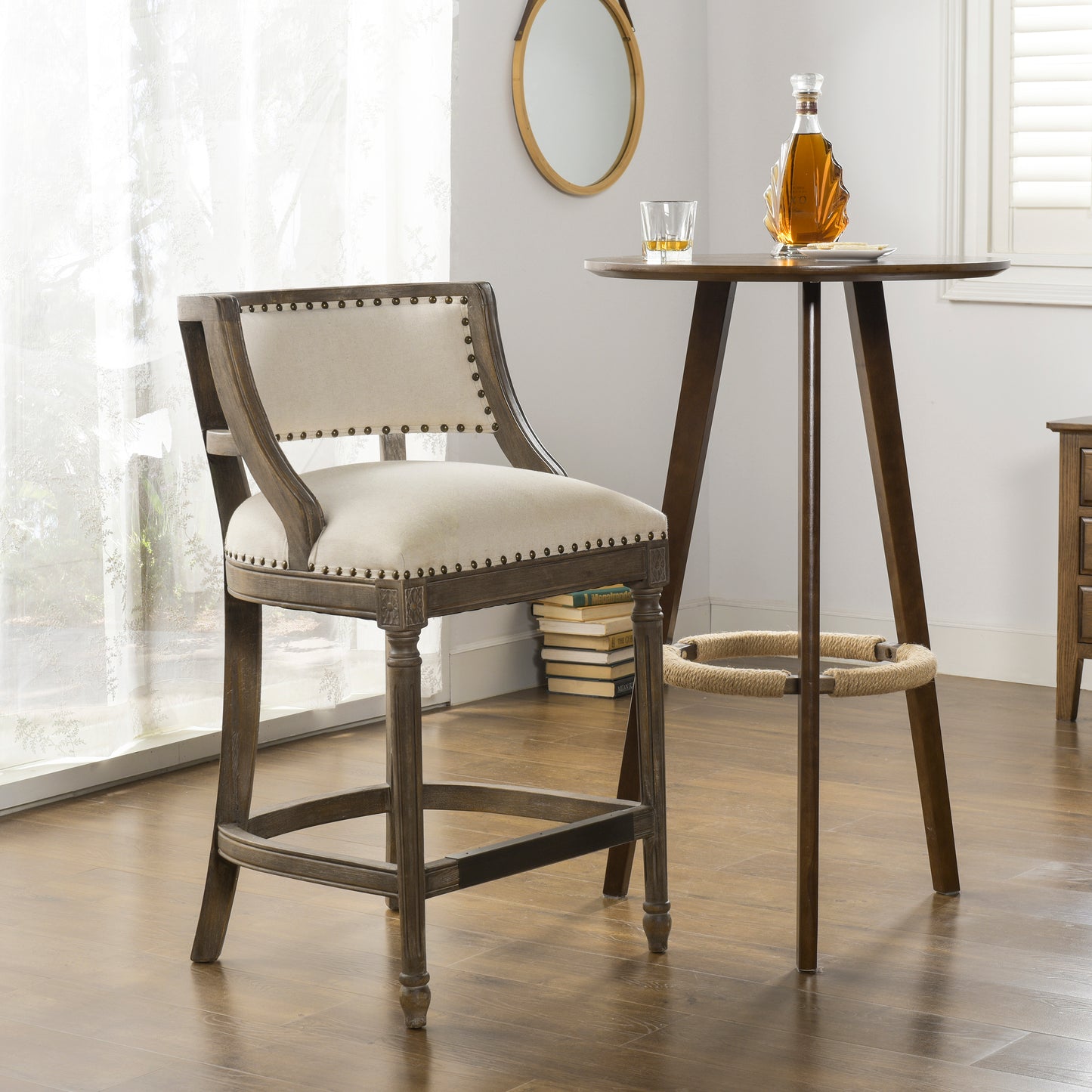 Rustic grey wooden bar stool with beige upholstered seat and nailhead trim