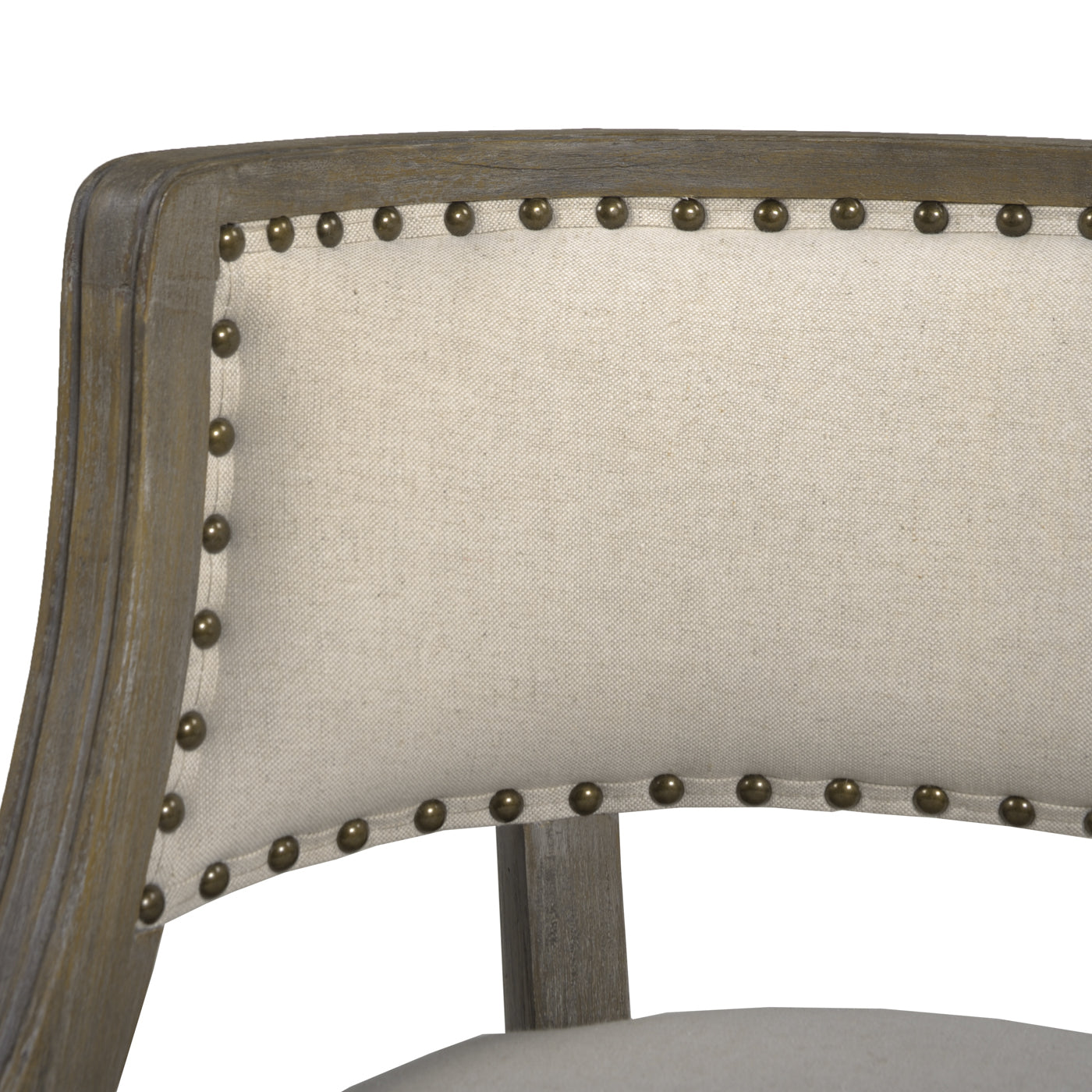 Detail of tufted linen accent chair back with antique brass nailhead trim