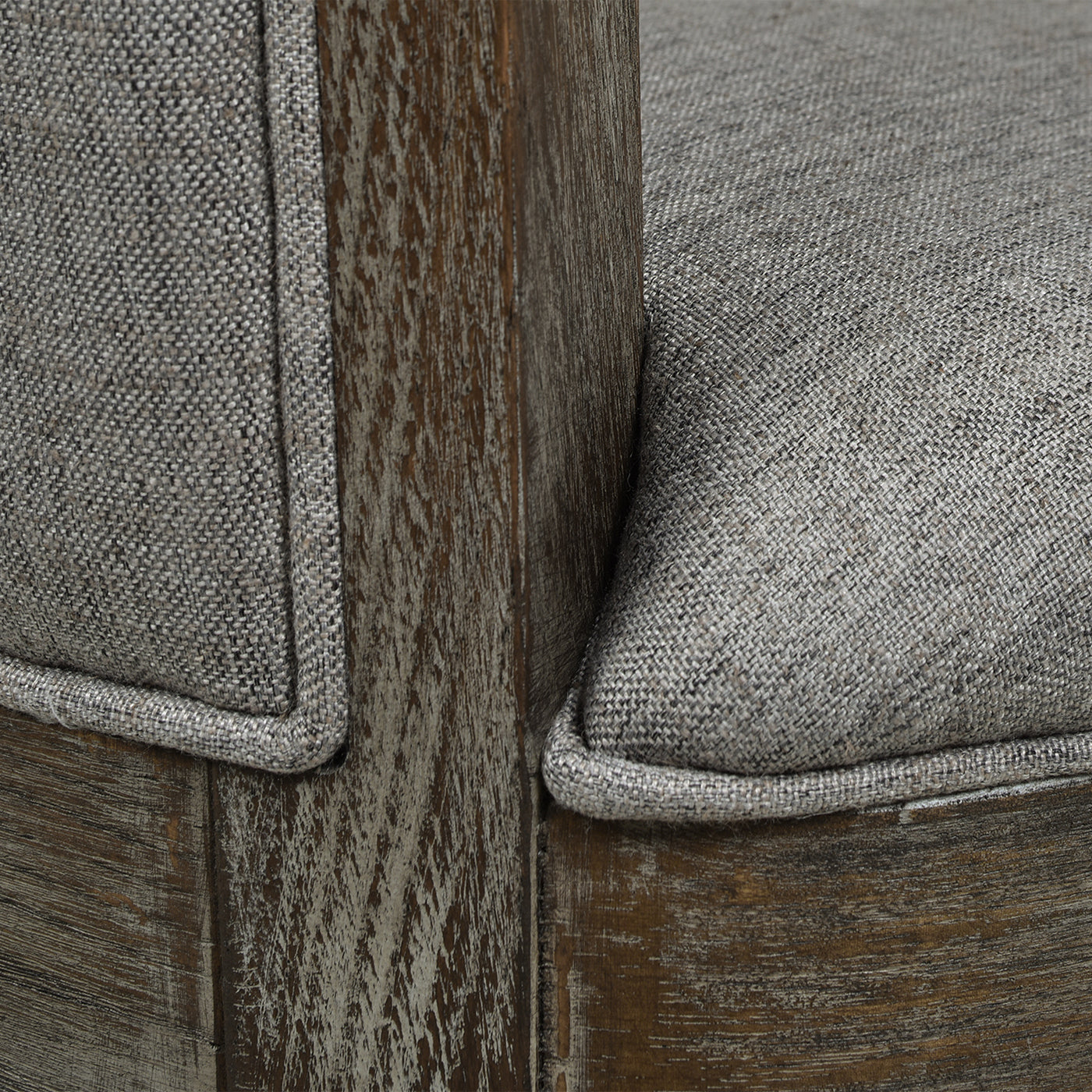 Close up of grey textured fabric armchair cushion with weathered wood frame