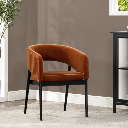 Orange velvet accent chair with ribbed back and black metal legs