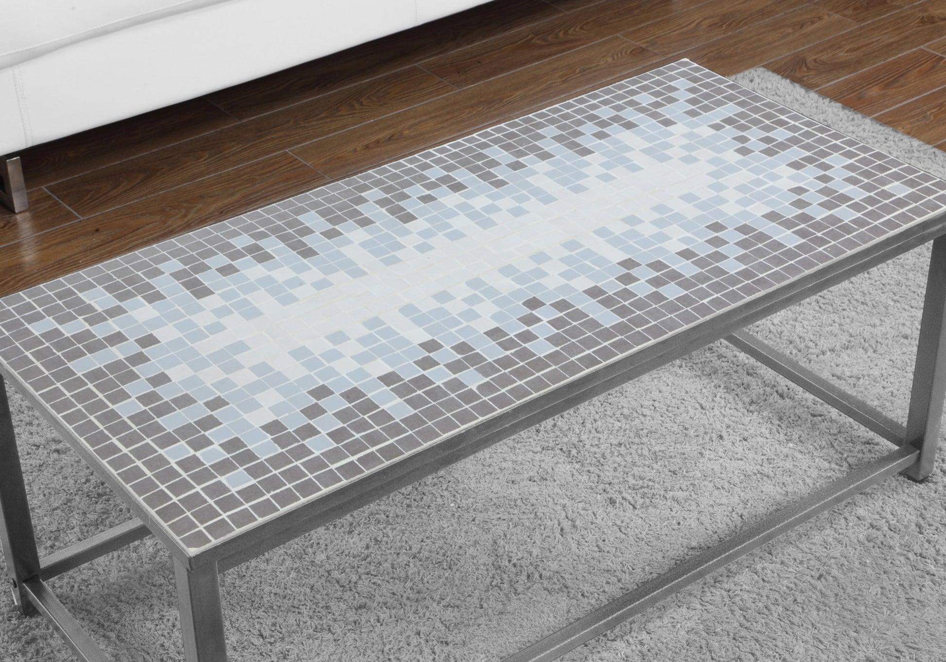 Rectangular coffee table with mosaic tile top in gray and blue hues on a shag rug