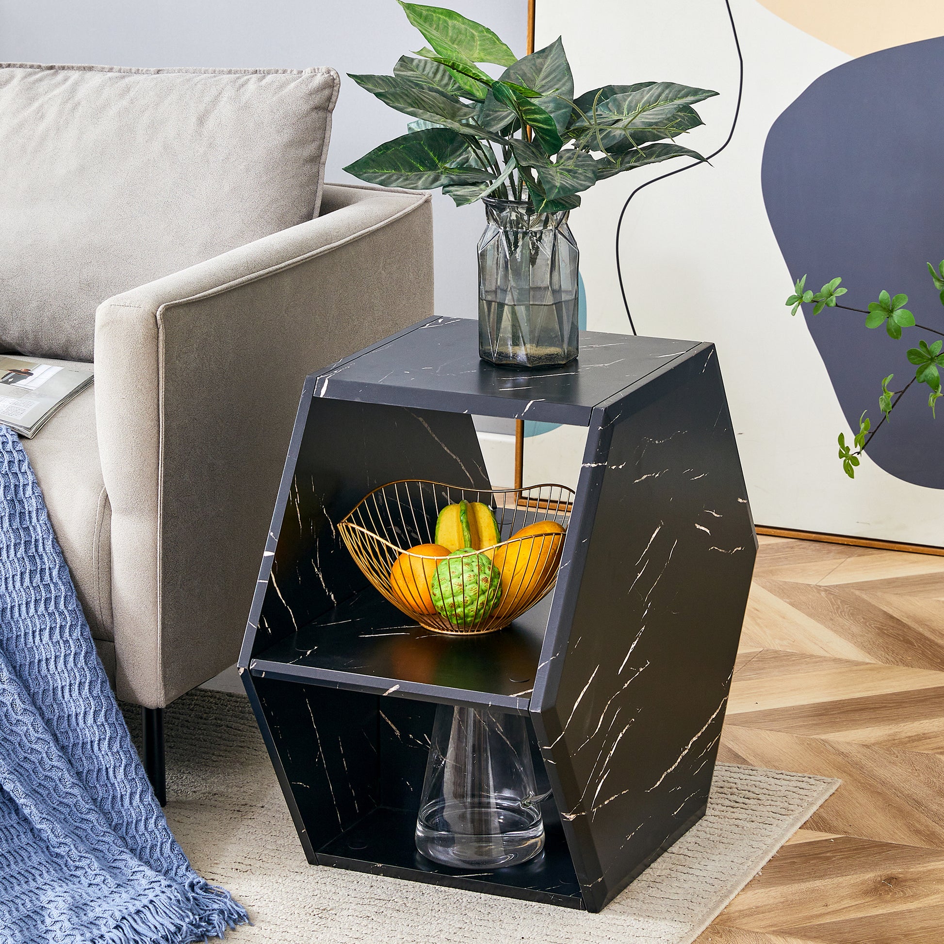 Hexagonal black marble end table with open shelving and gold fruit basket