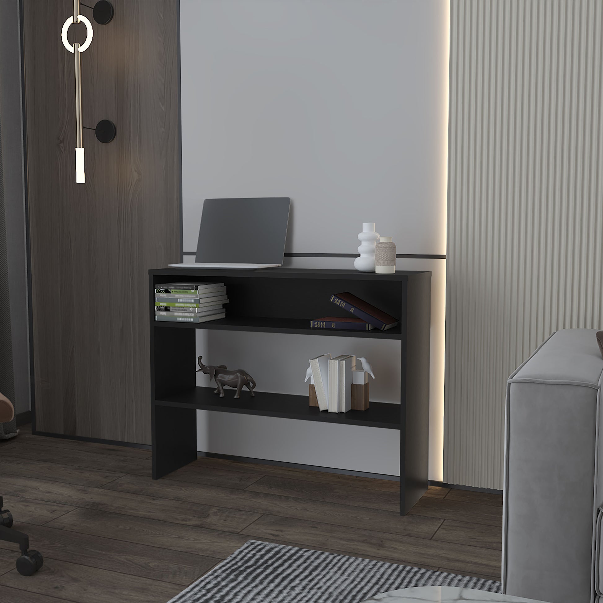 Black narrow bookshelf with three shelves holds laptop books and decor