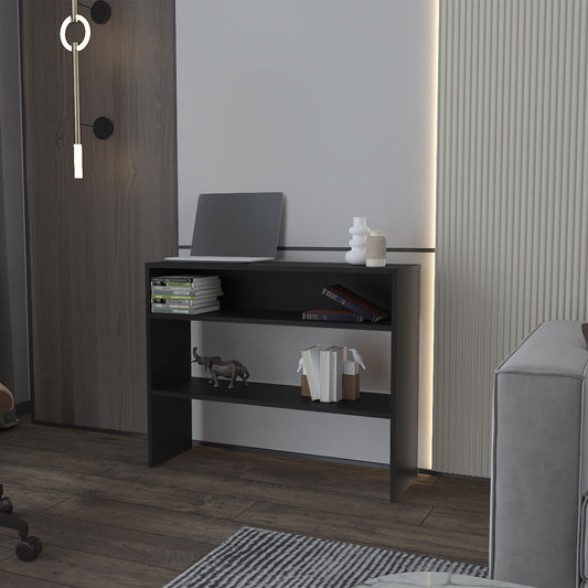 Black narrow bookshelf with three shelves holds laptop books and decor