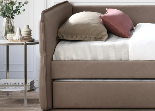 Taupe upholstered daybed with tufted back cushion and white textured bedding