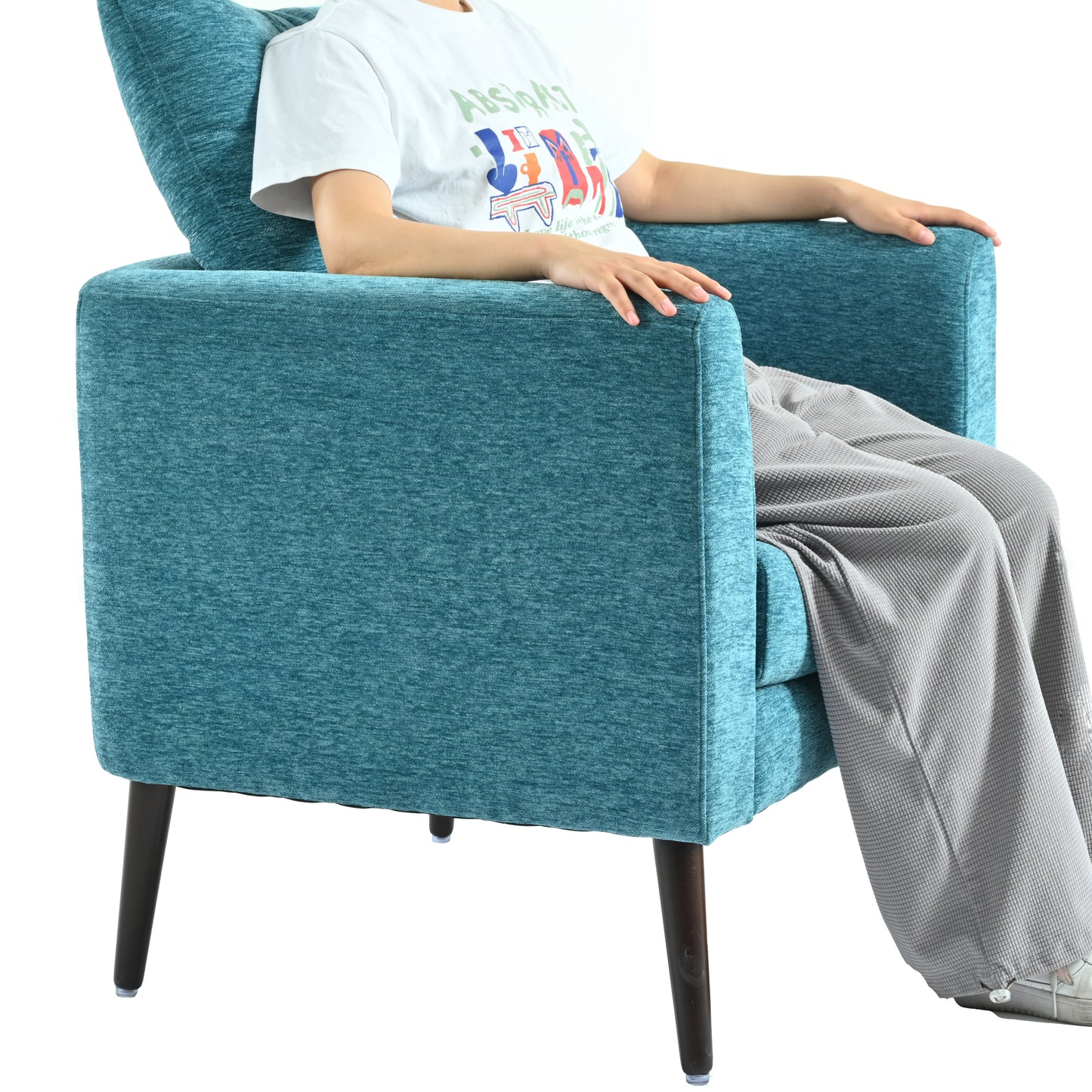 Teal upholstered armchair with tapered wooden legs and a person seated perfect for living room decor