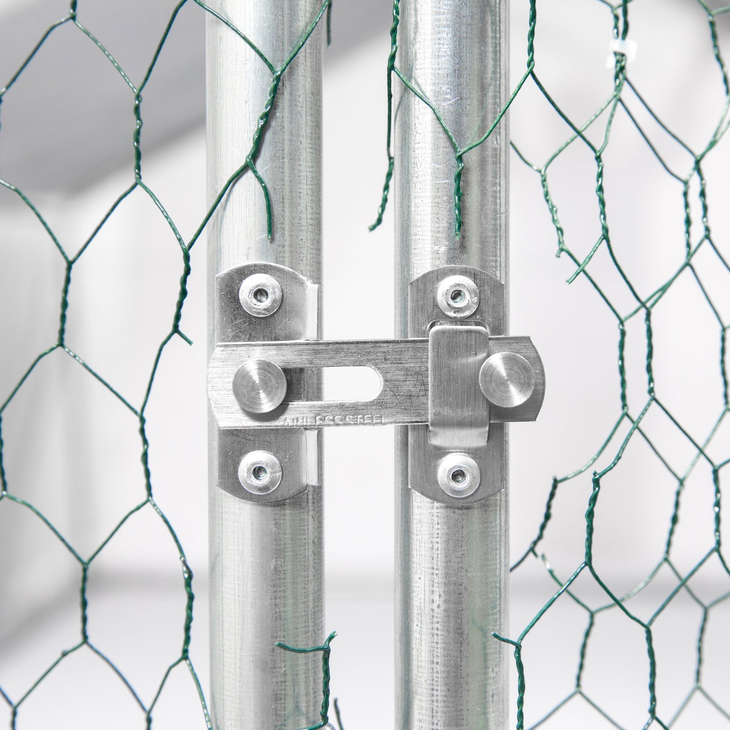 Heavyduty latch securing two galvanized metal fence posts made of stainless steel