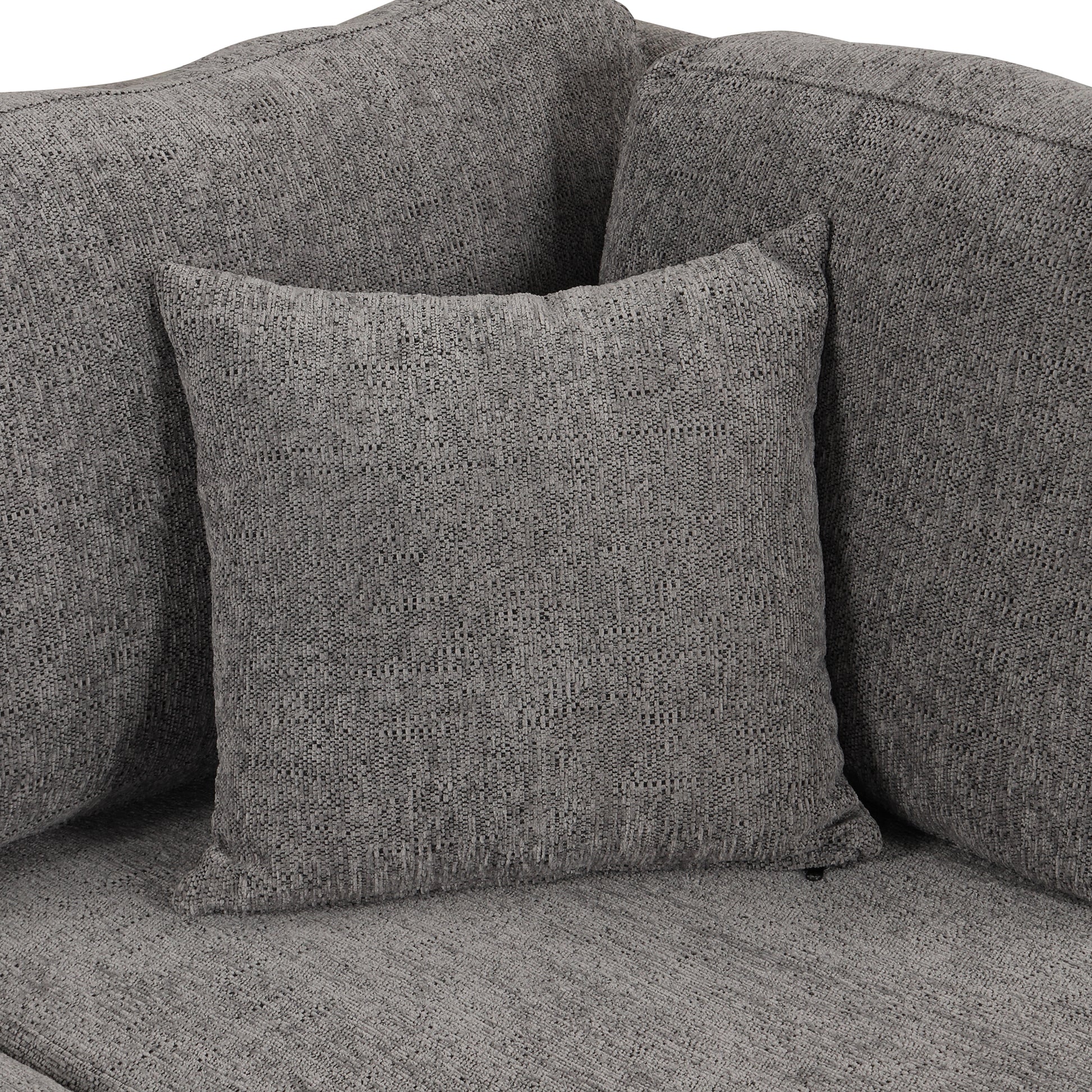 Closeup of a plush charcoal grey sofa with textured fabric and accent pillows