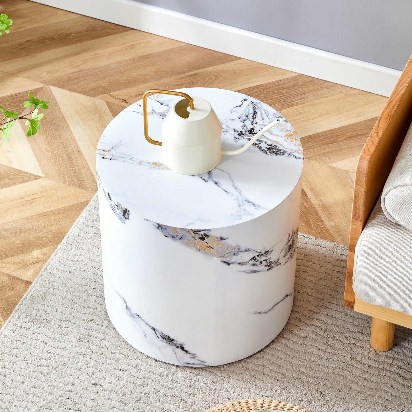 Round white marble end table with gold accents and a gold watering can